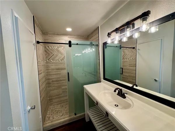 a bathroom with a sink mirror and shower