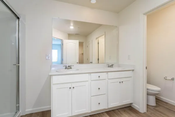 a bathroom with a double vanity sink and a toilet