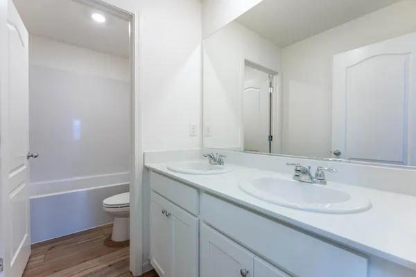 a bathroom with a granite countertop sink a toilet and a large mirror