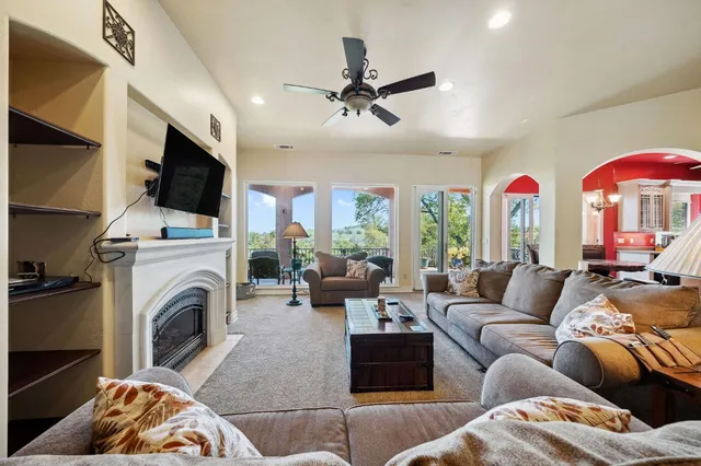 a living room with fireplace furniture and a large window