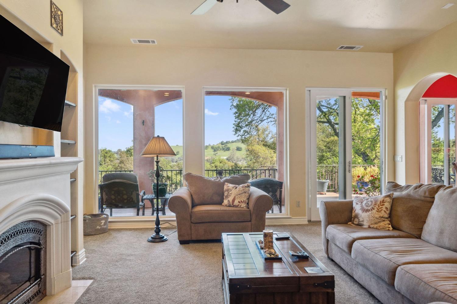 125 Raylan Drive Sutter Creek, CA 95685 - Photo 14 of 79 a living room with furniture a large window and a flat screen tv