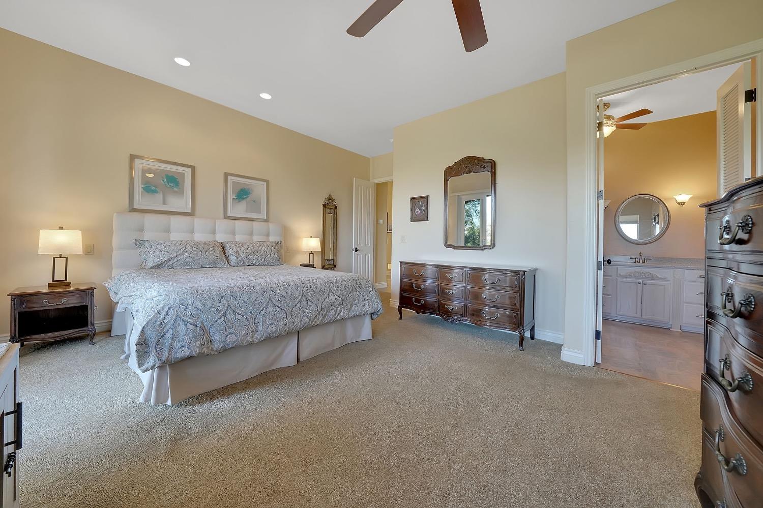125 Raylan Drive Sutter Creek, CA 95685 - Photo 32 of 79 a spacious bedroom with a bed and a lamp