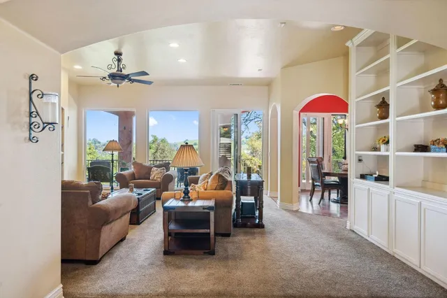 a living room with furniture a large window and a flat screen tv