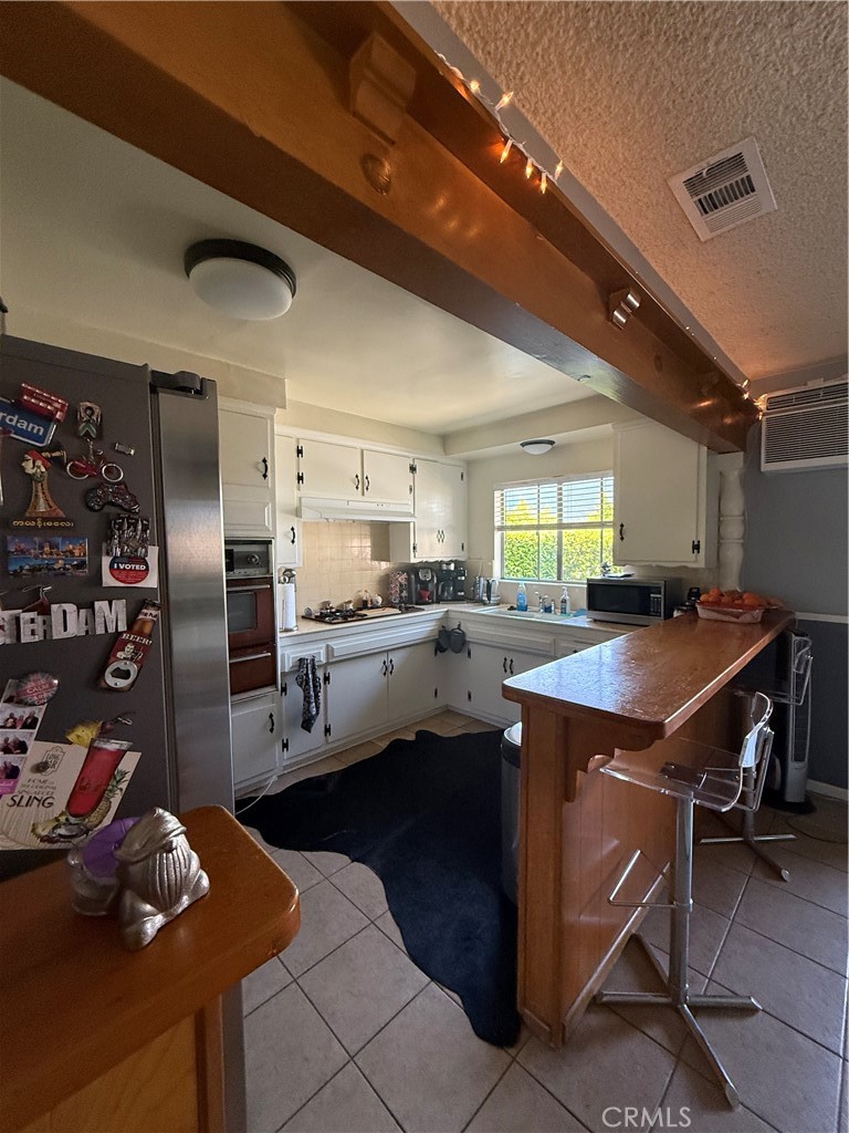 4535 Ramsdell Avenue La Crescenta, CA 91214 - Photo 11 of 28 a kitchen with stainless steel appliances kitchen island granite countertop a table chairs and a refrigerator