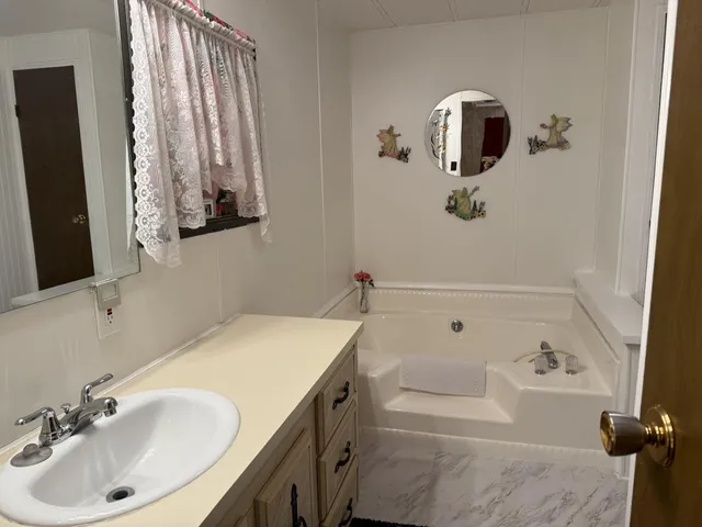 a bathroom with a tub sink and mirror
