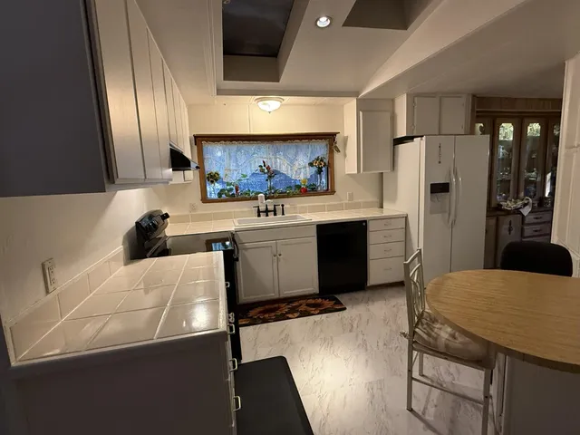 a kitchen with stainless steel appliances a sink a stove a refrigerator and cabinets