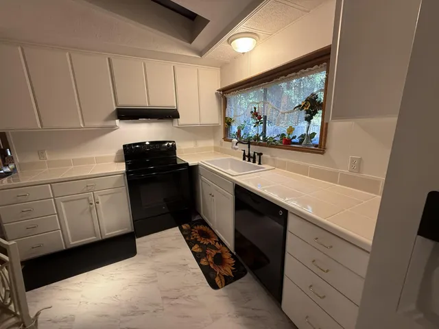 a kitchen with a sink stove and cabinets
