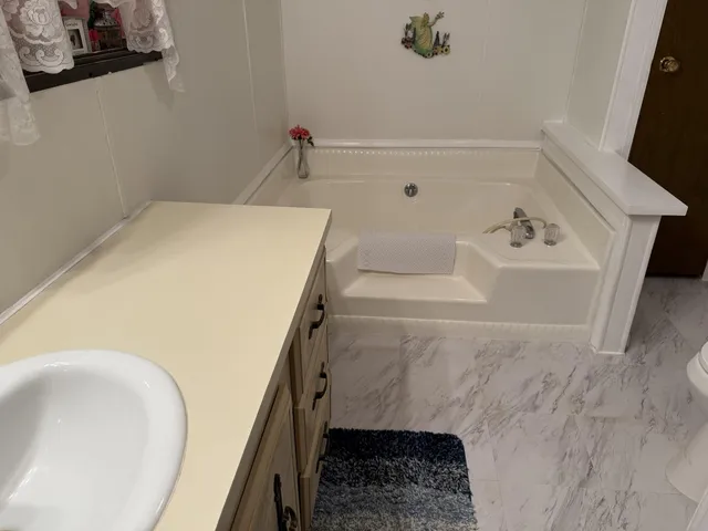 a bathroom with a tub sink and mirror