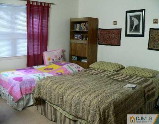 37 Judson Street, Unit 8A Edison, NJ 08837 - Photo 2 of 7 a bedroom with a bed and painting on the wall