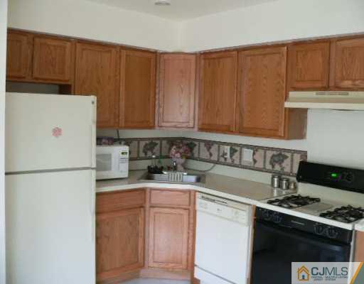 37 Judson Street, Unit 8A Edison, NJ 08837 - Photo 3 of 7 a kitchen with a white stove top oven and refrigerator