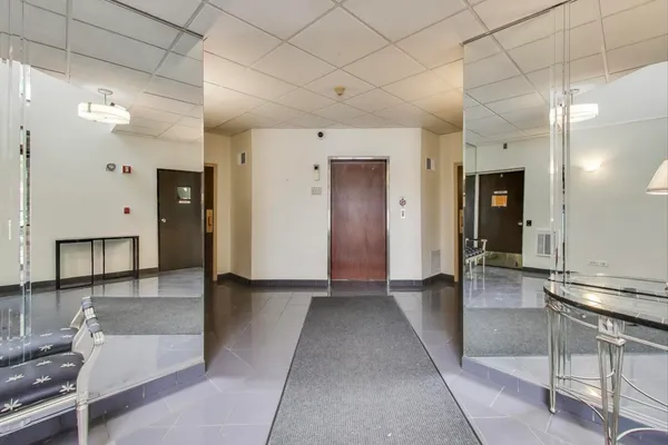 a view of a hallway with wooden floor and cabinet