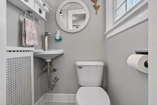 a bathroom with a toilet a sink and a mirror