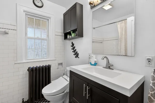 a bathroom with a toilet a sink and mirror