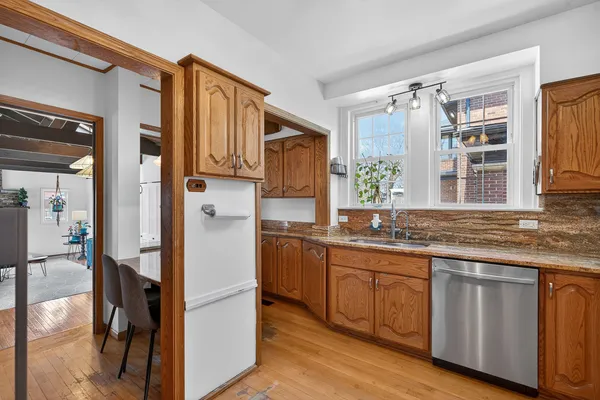 a kitchen with stainless steel appliances granite countertop a refrigerator and wooden cabinets