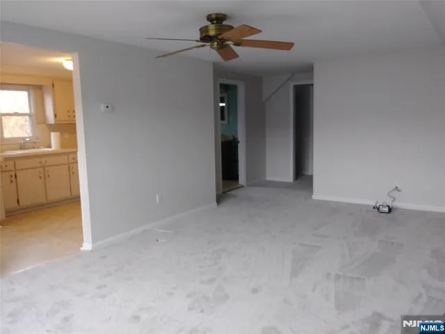 a view of an empty room with window and cabinet