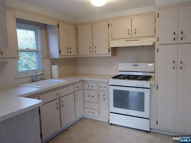 a kitchen with cabinets appliances a sink and a window