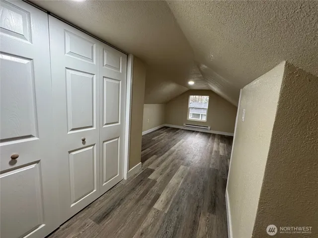 a view of a hallway with wooden floor and closet area