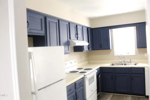 a kitchen with a sink cabinets and a window
