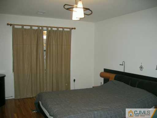 1812 Raspberry Court Edison, NJ 08817 - Photo 6 of 8 a bed room with a bed and a chandelier