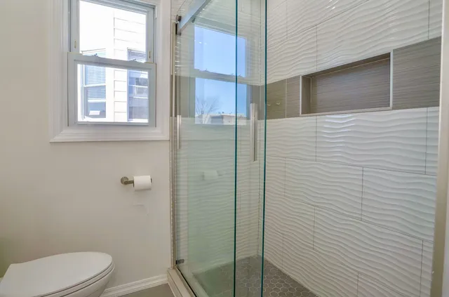 a bathroom with a toilet and a shower