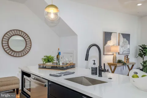 a kitchen with a sink and a stove with wooden floor