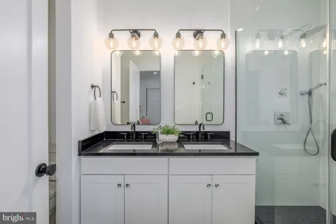 a bathroom with double sink and a mirror