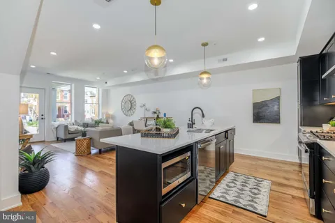 a kitchen with a sink stove and wooden floor