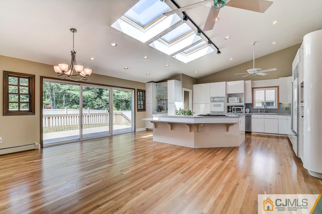 16 Mockingbird Road Edison, NJ 08820 - Photo 6 of 25 a large kitchen with stainless steel appliances granite countertop a stove a refrigerator a sink dishwasher and a dining table with wooden floor