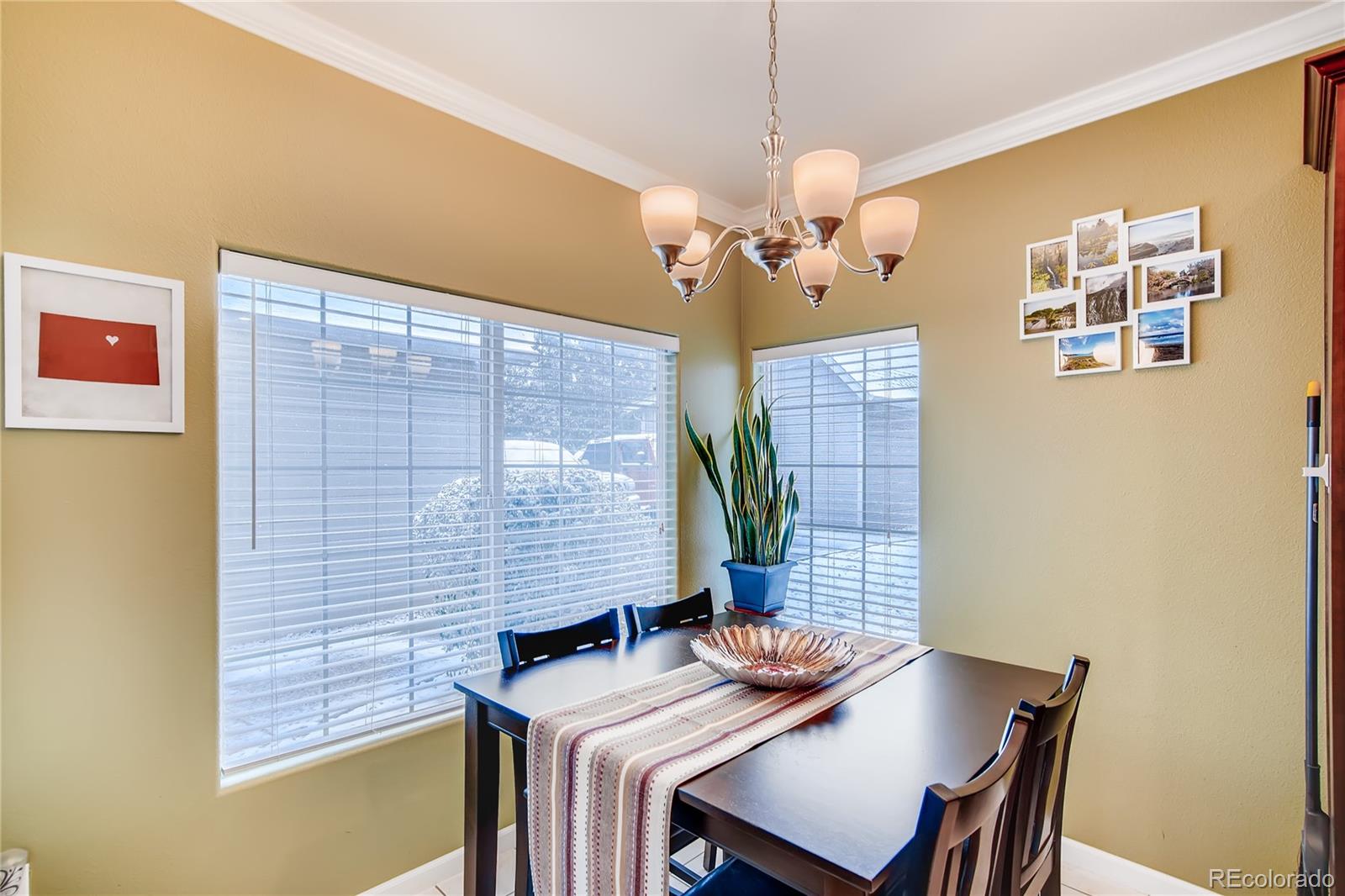 8427 South Thunder Ridge Way, Unit 103 Highlands Ranch, CO 80126 - Photo 4 of 10 a view of a dining room with furniture and chandelier