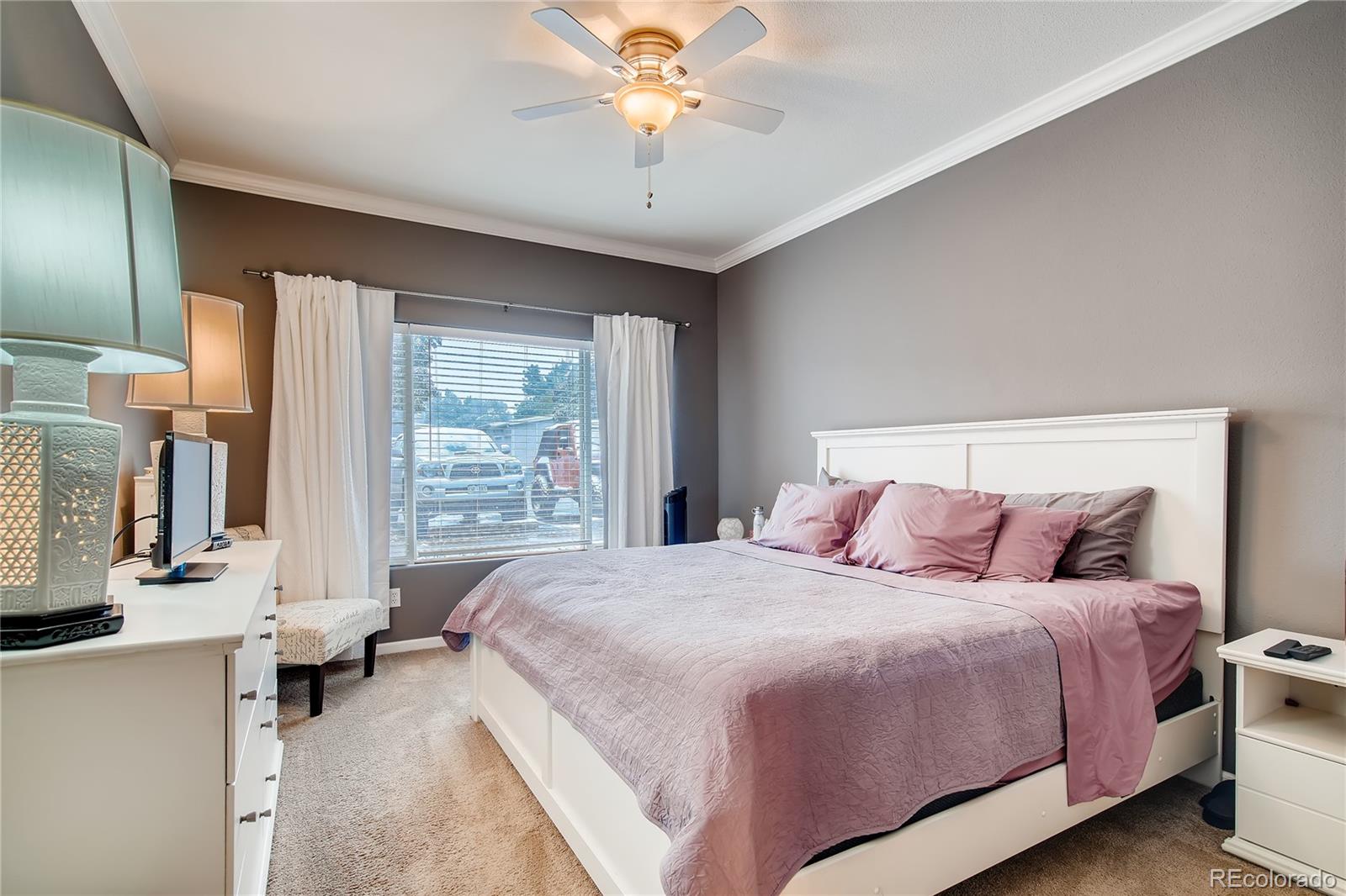 8427 South Thunder Ridge Way, Unit 103 Highlands Ranch, CO 80126 - Photo 5 of 10 a bedroom with a balcony a bed and a chandelier