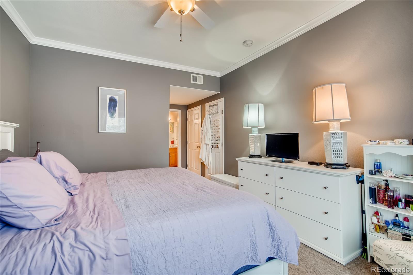 8427 South Thunder Ridge Way, Unit 103 Highlands Ranch, CO 80126 - Photo 6 of 10 a bedroom with a bed and a flat screen tv