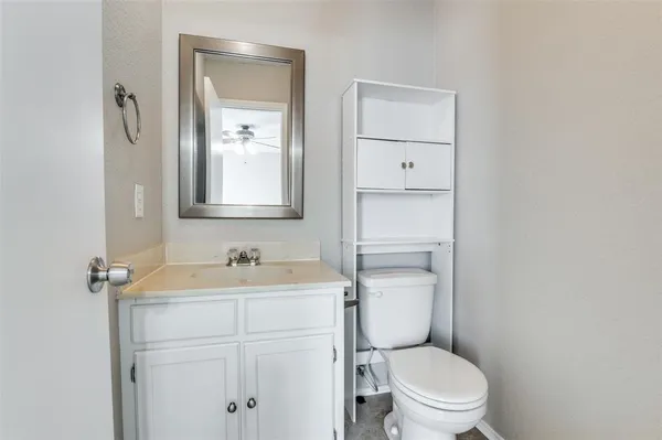 a bathroom with a toilet sink vanity and mirror