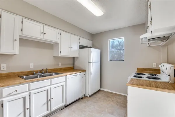 a kitchen with cabinets appliances and a window