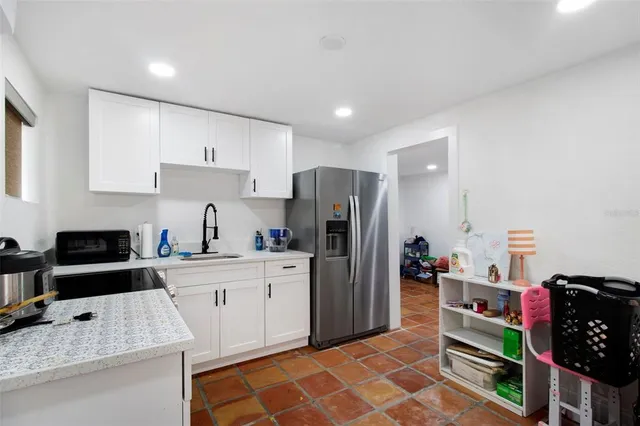 a kitchen with stainless steel appliances granite countertop a refrigerator and a stove top oven
