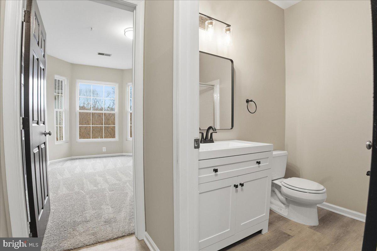 20419 Riverbend Square, Unit 301 Sterling, VA 20165 - Photo 18 of 25 a bathroom with a sink a toilet a mirror and shower