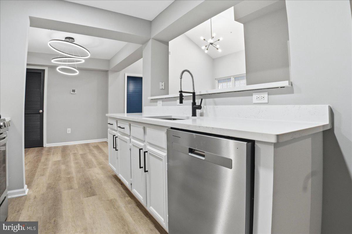 20419 Riverbend Square, Unit 301 Sterling, VA 20165 - Photo 8 of 25 a kitchen with stainless steel appliances a sink and a refrigerator