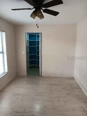 an empty room with chandelier fan