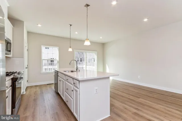 a kitchen with a sink and wooden floor