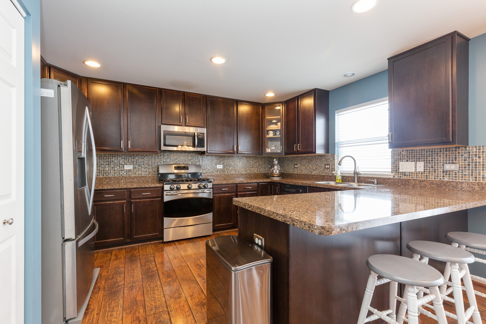 26 Boathouse Road Pingree Grove, IL 60140 - Photo 6 of 12 a kitchen with stainless steel appliances granite countertop a sink stove microwave and refrigerator