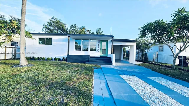 a front view of a house with a garden and yard