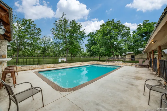 a view of a house with swimming pool and sitting area