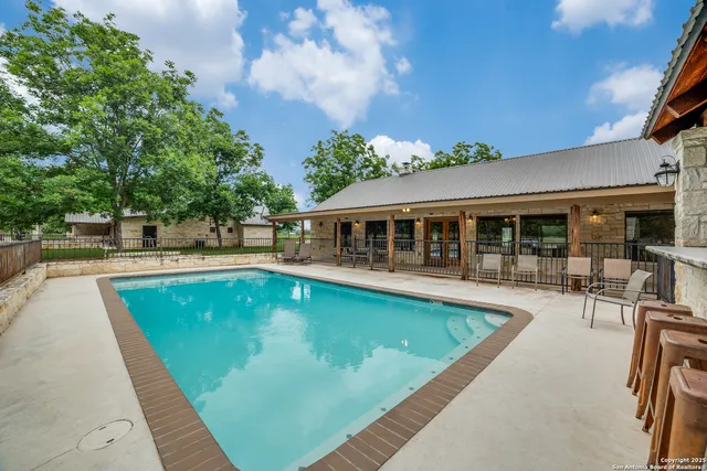 a view of a house with swimming pool and sitting area