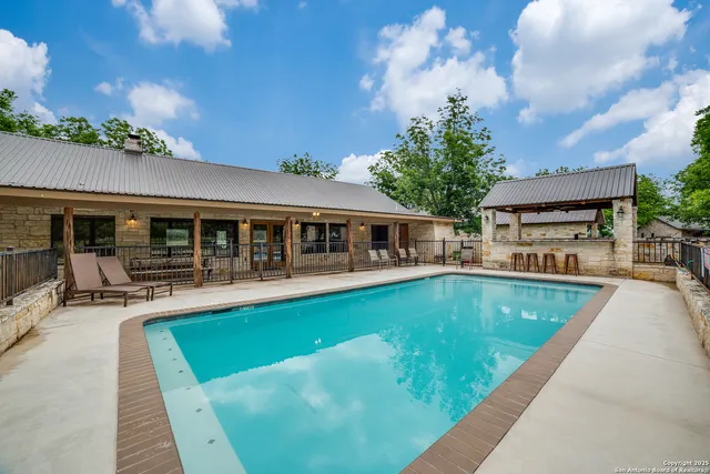 a view of a swimming pool with a patio and a yard