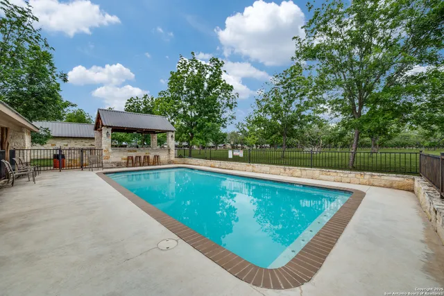 a front view of a house with swimming pool having outdoor seating