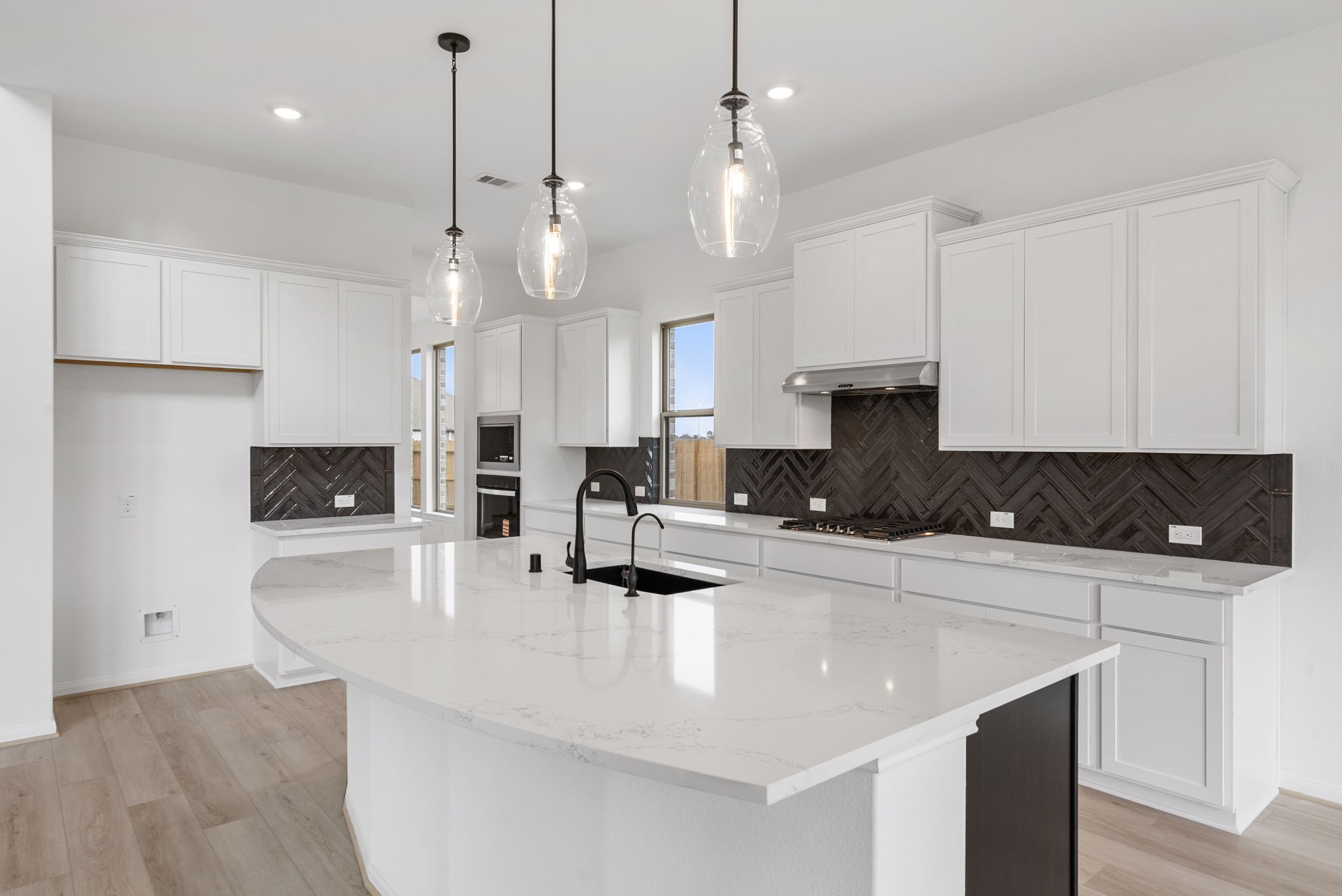 18810 Forested Street Manvel, TX 77578 - Photo 3 of 35 a large kitchen with kitchen island a large counter top and stainless steel appliances
