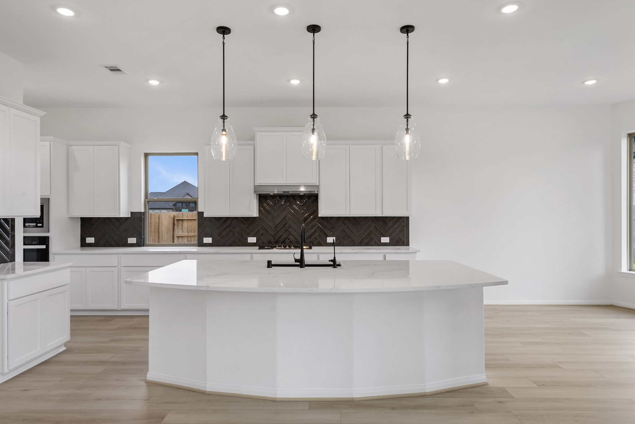 18810 Forested Street Manvel, TX 77578 - Photo 4 of 35 a large kitchen with kitchen island a stove a sink a center island and wooden floor