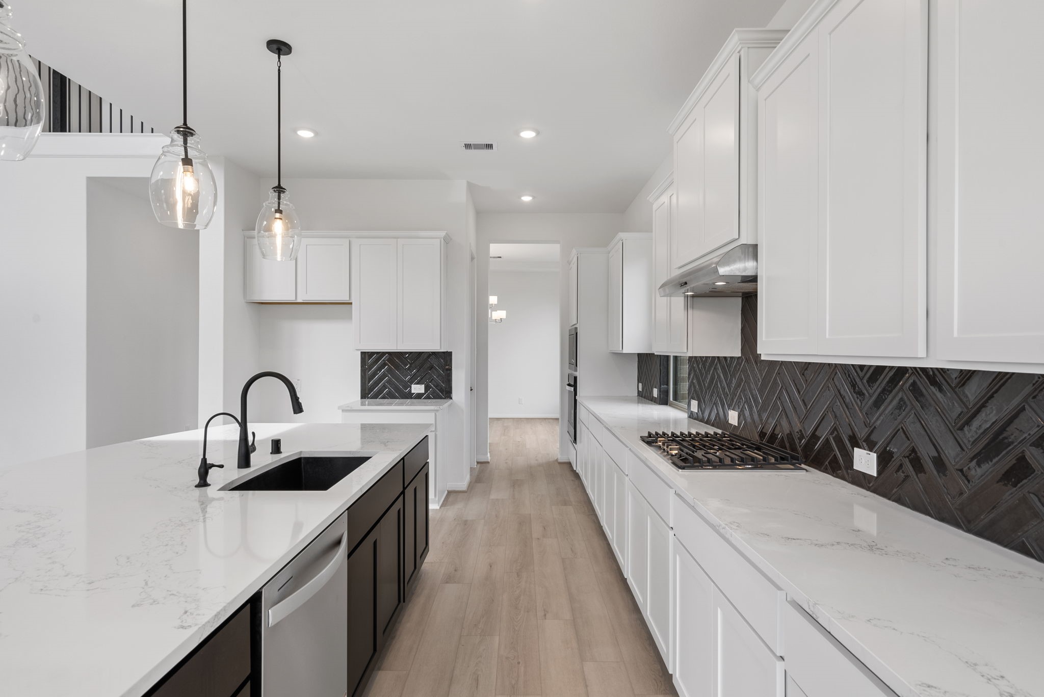 18810 Forested Street Manvel, TX 77578 - Photo 6 of 35 a kitchen with kitchen island granite countertop a sink and white cabinets