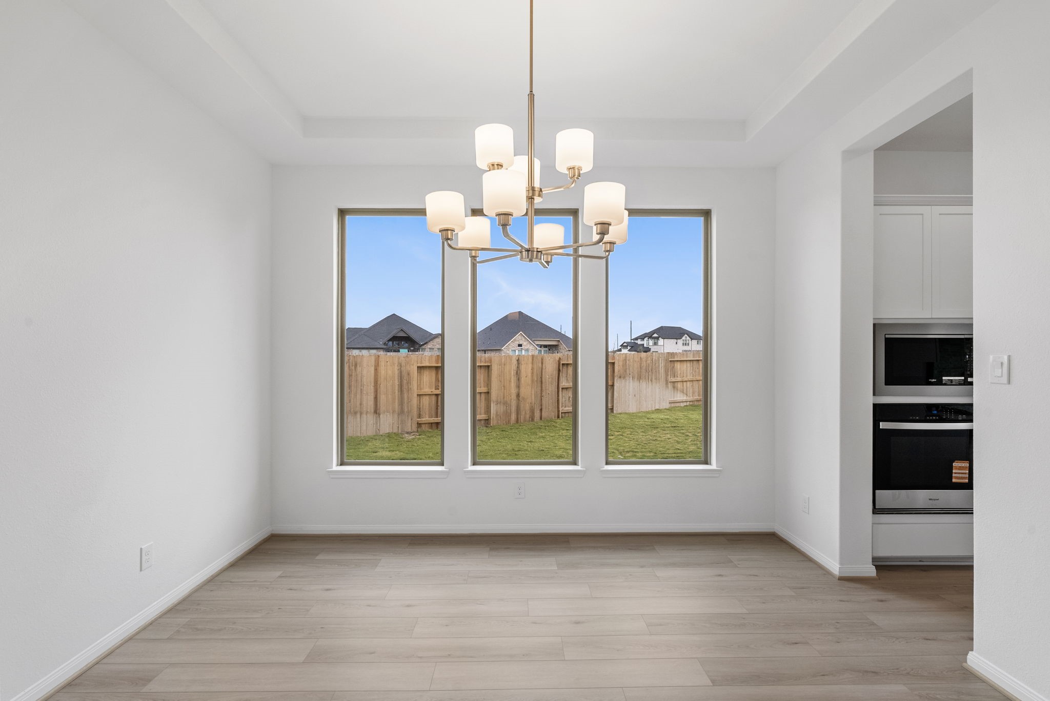 18810 Forested Street Manvel, TX 77578 - Photo 8 of 35 a view of an empty room with chandelier wooden floor and windows