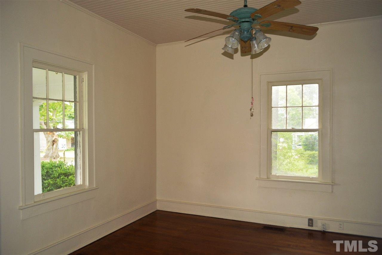 317 South Walnut Street Spring Hope, NC 27882 - Photo 10 of 14 a view of an empty room with wooden floor and window