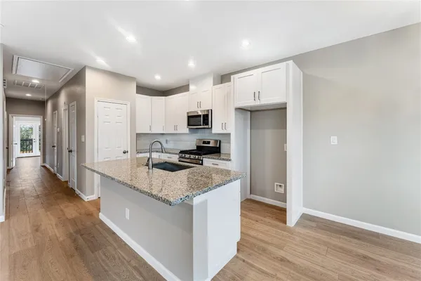 a kitchen with stainless steel appliances granite countertop a sink stove and refrigerator